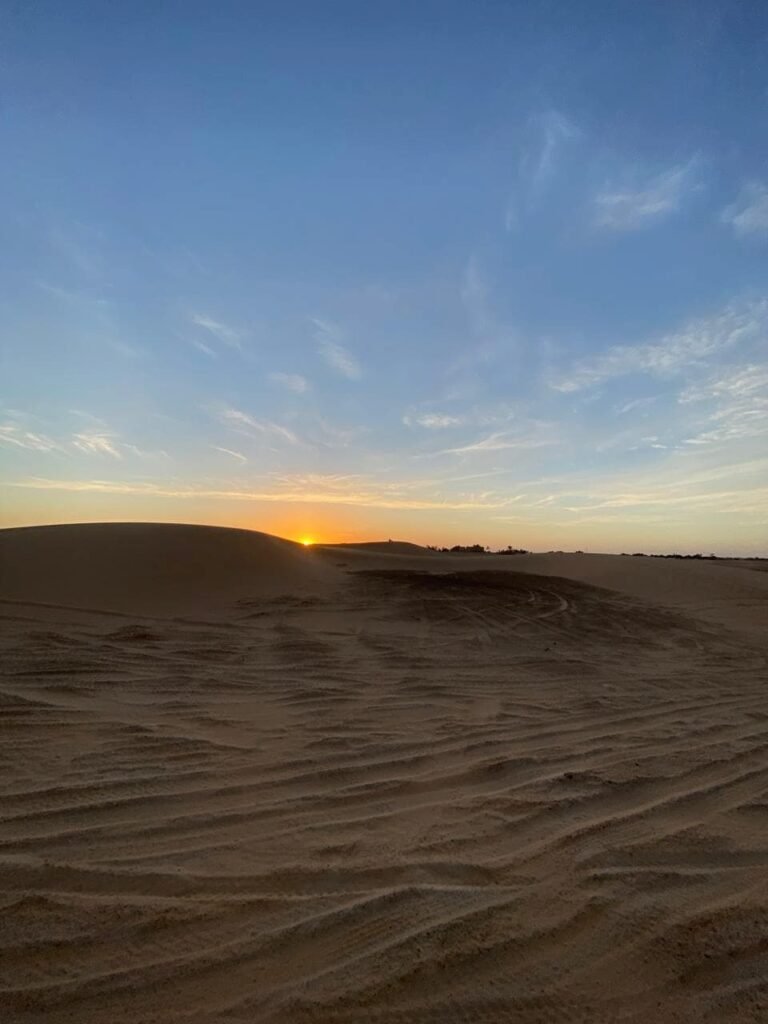 camel trekking at sunset in Erg Chebbi dunes on a 3-day group desert tour from Marrakech