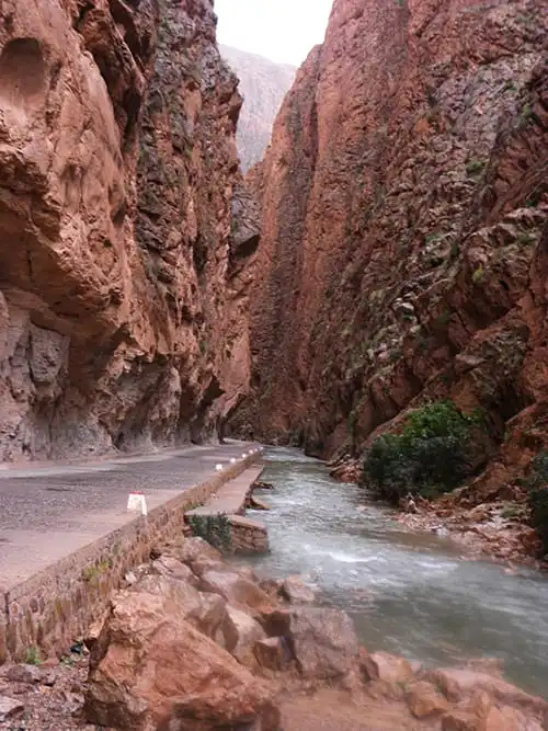Walking through Todra Gorge narrow canyon on a private 3-day desert tour from Fes to Marrakech